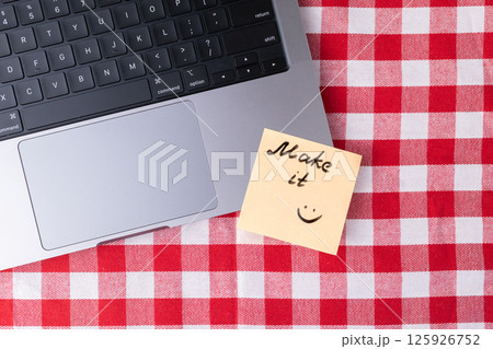 Sticky note with encouraging message Make it smiling placed on laptop promoting motivation and success 125926752
