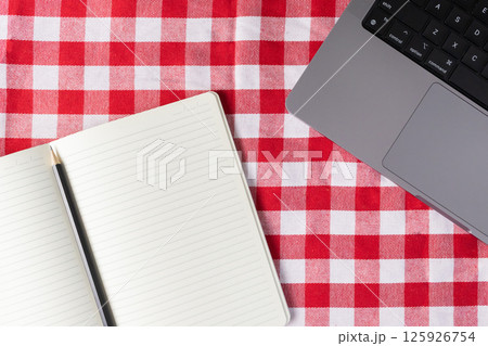 Blank notebook and pencil with laptop on tablecloth for remote work planning and creativity 125926754