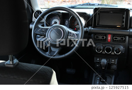 View from behind the driver's seat of the switched off instruments on the central panel of the car 125927515