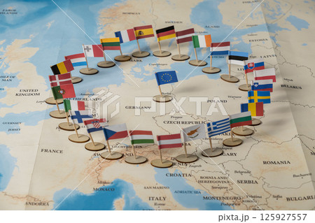 colorful flags of european union member countries arranged in a symbolic circle on a detailed political map of europe 125927557
