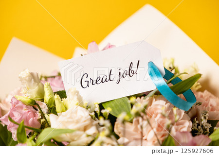 great job message on a beautiful floral bouquet with a congratulatory note, pastel flowers, and a yellow background for encouragement and celebration 125927606