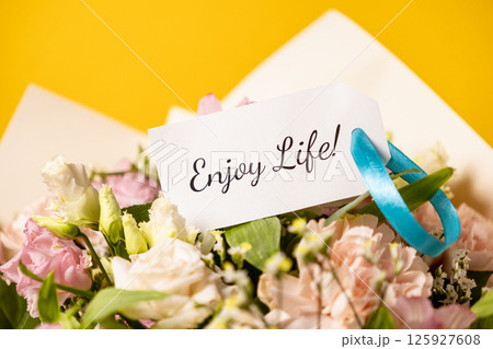 enjoy life message on a beautiful floral bouquet with a motivational note, pastel flowers, and a yellow background for inspiration and positivity enjoy life message on a beautiful floral bouquet with a motivational note, pastel flowers, and a yellow background for inspiration and positivity 125927608