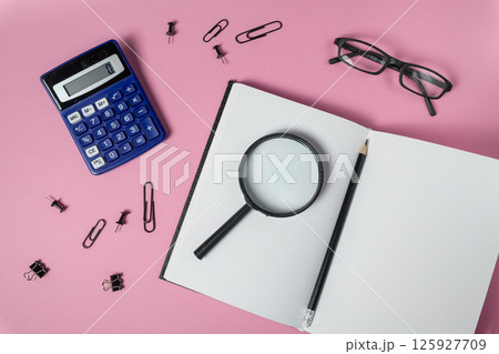 Blank notebook, calculator, office items on pink background flat lay symbolizes study, planning, analysis Blank notebook, calculator, office items on pink background flat lay symbolizes study, planning, analysis 125927709