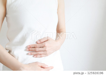 お腹を抑える女性 125928196
