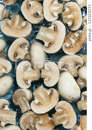 Raw White Mushrooms Champignons Close-Up Splash in a Water Top View Raw White Mushrooms Champignons Close-Up Splash in a Water Top View 125928255