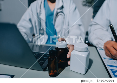 Male and female doctors are having a meeting in a hospital room. 125929594