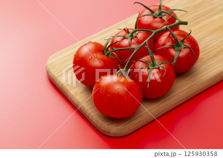 赤背景に房摘みトマト 125930358