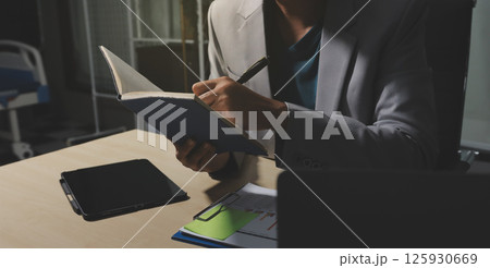 Working from home, Closeup business woman using laptop computer and analyzing financial report. 125930669