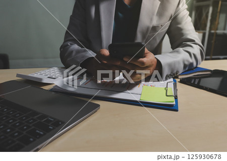 Working from home, Closeup business woman using laptop computer and analyzing financial report. 125930678