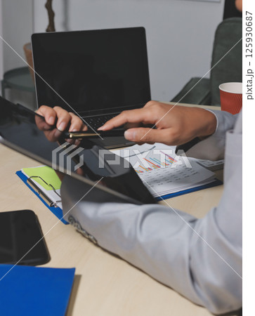 Working from home, Closeup business woman using laptop computer and analyzing financial report. Working from home, Closeup business woman using laptop computer and analyzing financial report. 125930687