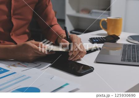 Working from home, Closeup business woman using laptop computer and analyzing financial report. Working from home, Closeup business woman using laptop computer and analyzing financial report. 125930690
