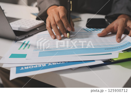 Working from home, Closeup business woman using laptop computer and analyzing financial report. 125930712