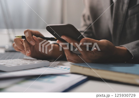 Working from home, Closeup business woman using laptop computer and analyzing financial report. 125930729