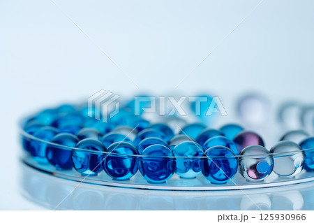Collagen molecules in Petri dish on blue. Hyaluronic acid skin care, collagen serum drop. Abstract moisturiser collagen peptide serum drop. Collagen molecules in Petri dish on blue. Hyaluronic acid skin care, collagen serum drop. Abstract moisturiser collagen peptide serum drop. 125930966