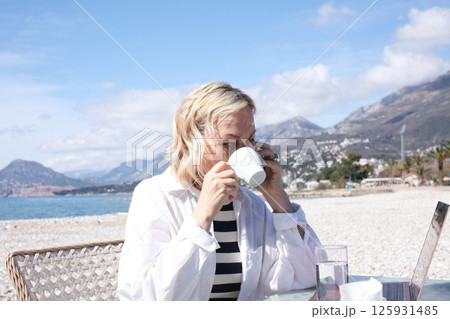 mature woman working outside in caffe on beach coast, lifestyle people concept 125931485