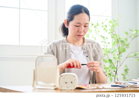 ハンドメイドのアクセサリーを作る女性 125931715