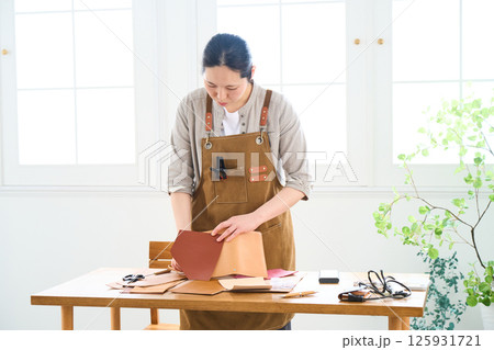 ハンドメイドの革製品を作る女性　レザークラフト 125931721