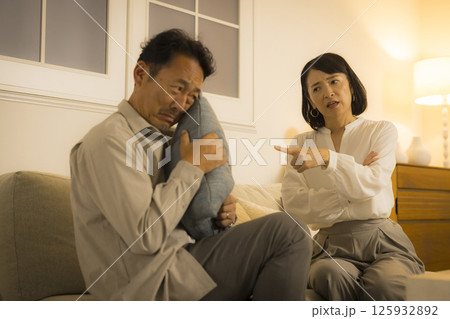 夜のリビングで喧嘩するミドル夫婦 夜のリビングで喧嘩するミドル夫婦 125932892