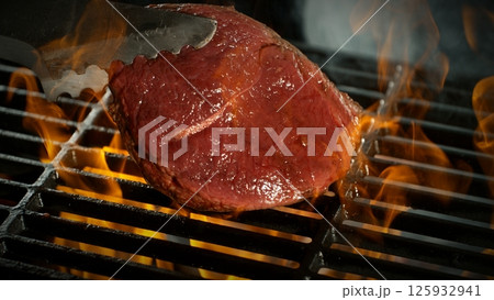 Close-up of Beef Steak on a Grill with Roaring Flames 125932941