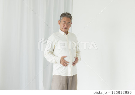 お腹の贅肉に悩むシニア男性 お腹の贅肉に悩むシニア男性 125932989