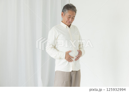 お腹の贅肉に悩むシニア男性 お腹の贅肉に悩むシニア男性 125932994