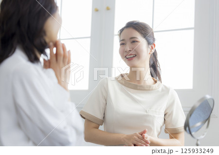 お肌のお手入れをアドバイスする女性　 125933249
