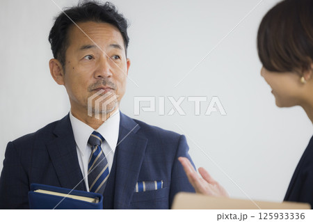 オフィスで打ち合わせをするビジネスマンとビジネスウーマン 125933336