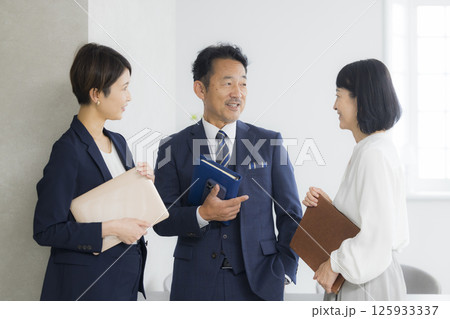 オフィスで打ち合わせをするビジネスマンとビジネスウーマン オフィスで打ち合わせをするビジネスマンとビジネスウーマン 125933337