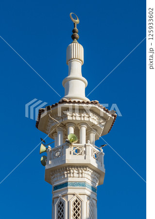 White minaret of mosque in Arabic city	 125933602