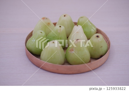 a woven basket filled with green water apples a woven basket filled with green water apples 125933822