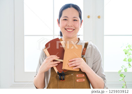 ハンドメイドの革製品を作る女性　レザークラフト 125933912