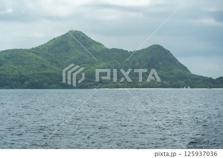 Mahe island in Seychelles, lush green hills and sandy beach seen across calm ocean 125937036