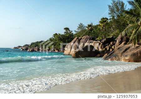 Anse Lazio beach on Seychelles with turquoise ocean, granite rocks, white sand, lush palms 125937053