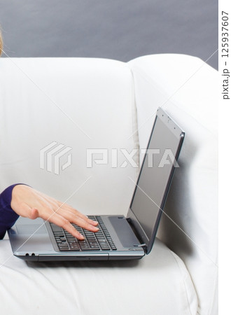 Hands of woman with laptop. Relaxing or working with computer 125937607