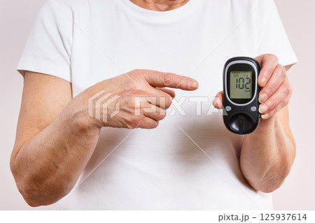 Senior woman and glucometer with result of sugar level. Diabetes in old age Senior woman and glucometer with result of sugar level. Diabetes in old age 125937614