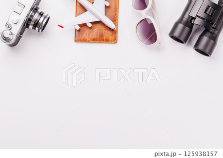 Travel-themed flat lay with toy airplane, camera, and coffee 125938157