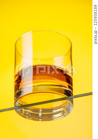 A classic whiskey glass filled with golden amber whiskey A classic whiskey glass filled with golden amber whiskey 125938189
