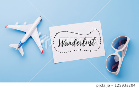 Travel-themed flat lay with card, sunglasses and toy airplane 125938204