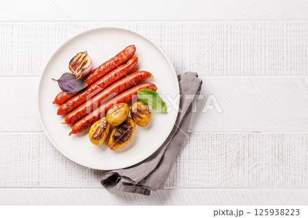 Grilled sausages served with roasted baby potatoes 125938223