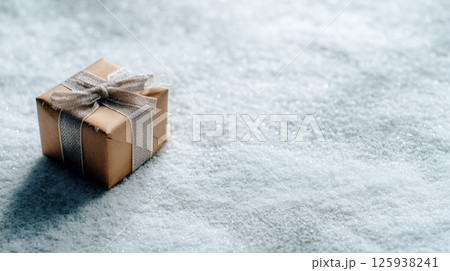 Gift Box Tied With Ribbon on Snow in Wintertime 125938241
