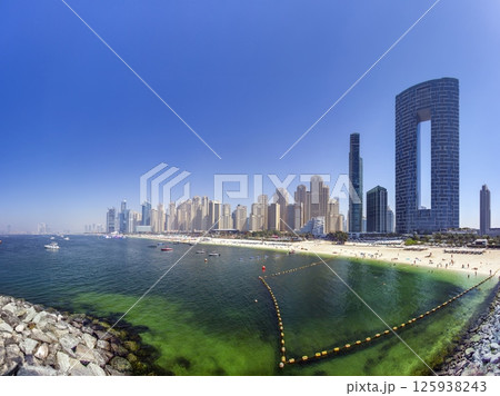 Dubai beach with highrise skyline and clear sea water Dubai beach with highrise skyline and clear sea water 125938243