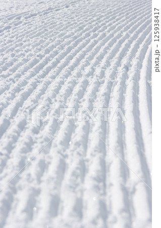 スキー場のゲレンデの雪面に残る圧雪車の跡 125938417