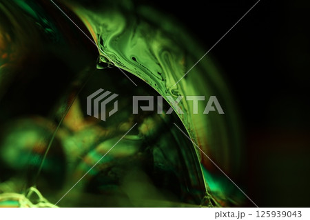 Green liquid surface on dark background, green Reflections of liquid in macro, green liquid surface, bubbles in macro, connection of bubbles in macro, cell from liquid, dark background, glossy surface 125939043
