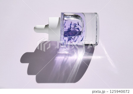 A bottle of purple face serum. 125940072