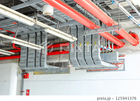 electrical steel pipeline, Electrical cable wire way on wall, cable routing between electrical distribution panel with equipment, industry construction concept background. 125941376