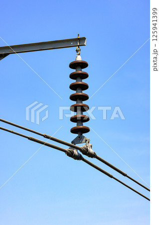 porcelain insulator on High voltage post, High voltage tower, show with high voltage construction and power lines. porcelain insulator on High voltage post, High voltage tower, show with high voltage construction and power lines. 125941399