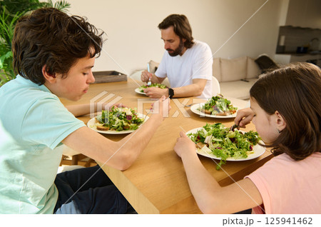 Family Enjoying a Healthy Homemade Vegetarian Meal Together in Modern Home Family Enjoying a Healthy Homemade Vegetarian Meal Together in Modern Home 125941462