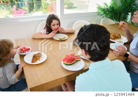 Family Enjoying Breakfast Together in a Bright and Modern Setting Family Enjoying Breakfast Together in a Bright and Modern Setting 125941484