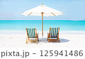 Beautiful tropical island scenery, two sun beds, loungers, umbrella under palm tree. White sand, sea view with horizon, idyllic blue sky, calmness and relaxation. Inspirational beach resort hotel 125941486