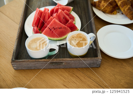 Healthy Breakfast Spread with Fresh Watermelon, Coffee, and Croissants 125941525